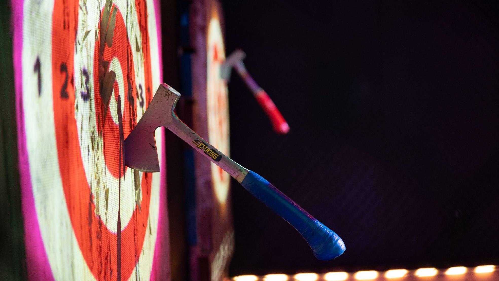 Close-up of an axe stuck in a glowing bullseye